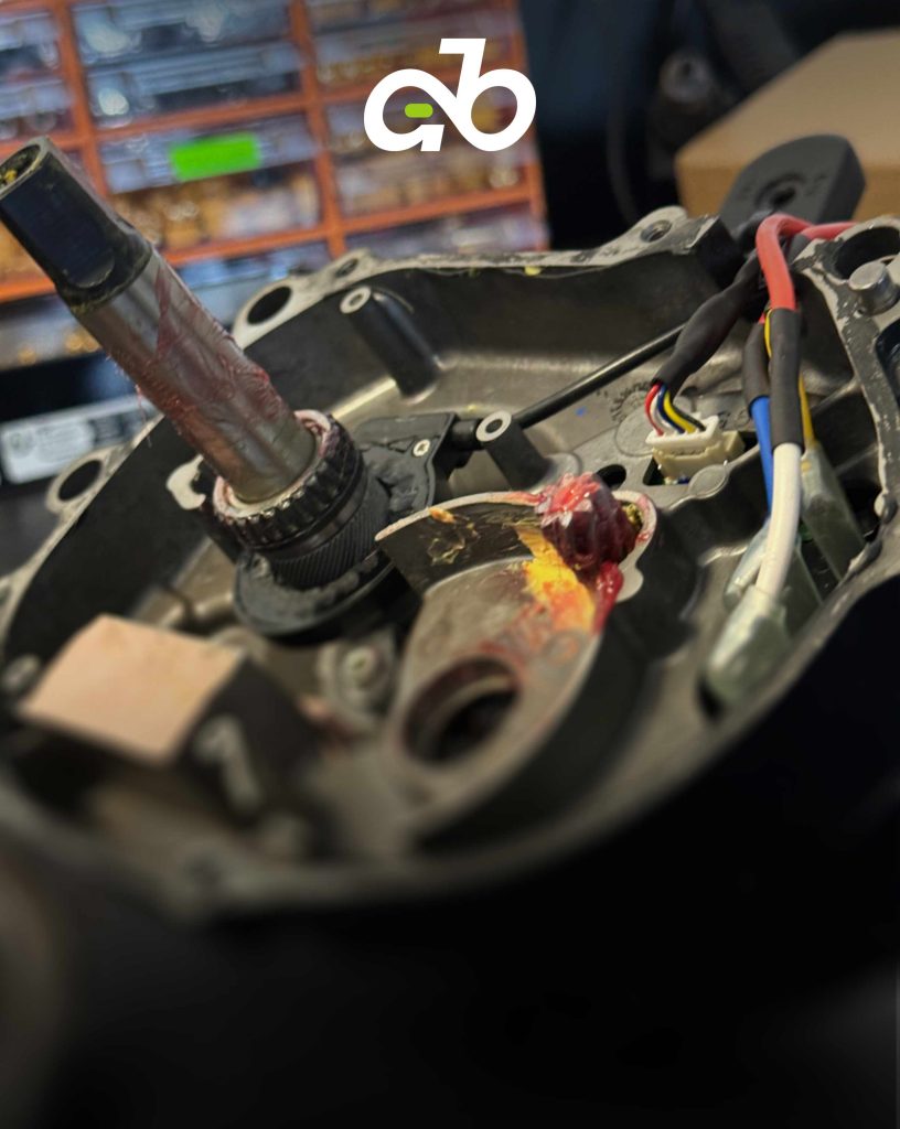 Close-up of e-bike motor (engine) with visible wiring and components for repair.
